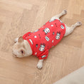 Load image into Gallery viewer, French bulldog laying flat on wooden floor wearing red plush pajamas with cow cartoon prints
