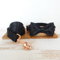 Load image into Gallery viewer, Black satin pet leash and bow tie collar on wooden board with rose gold clip