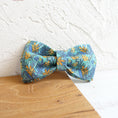 Load image into Gallery viewer, Teal floral fabric dog bow tie resting against white textured wall