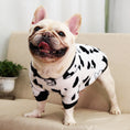 Cargar la imagen en la vista de la galería, Smiling dog in black and white coral fleece pajamas with cow pattern, standing facing camera