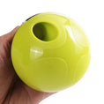 Load image into Gallery viewer, Hand holding the bottom of a bright green interactive food dispenser showing smooth rounded shape and dispensing hole