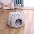 Load image into Gallery viewer, Gray plush cat bed placed on wooden floor near a curtain and wall art