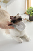 Load image into Gallery viewer, Using gray handle pet hair comb to groom a cat