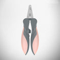 Load image into Gallery viewer, Close-up of pink and gray pet nail clipper showing blade and ergonomic handle on textured background