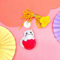 Load image into Gallery viewer, Close-up of felt cat-shaped toy with yellow elastic rope and suction cup on pink background
