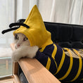 Load image into Gallery viewer, Side view of cat wearing bee hoodie lying on wooden arm of chair with hood up