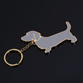 Load image into Gallery viewer, Metal dachshund dog keychain with grey enamel and gold-tone edges on black background