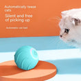 Load image into Gallery viewer, Blue automatic cat toy ball with LED power button next to a curious white cat