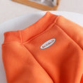 Cargar la imagen en la vista de la galería, Close-up of orange ribbed collar and shoulder seam detail on dog jumpsuit