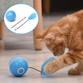 Load image into Gallery viewer, Orange tabby cat playing with blue LED light cat toy ball with blue feather attachment on floor
