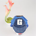 Charger l'image dans la visionneuse de la galerie, Close-up of a blue corduroy and mesh dog hat with embroidered G displayed in front of a flower pot