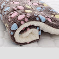 Load image into Gallery viewer, Rolled plush pet blanket with brown base and colorful paw prints, white fleece inside