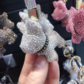 Charger l'image dans la visionneuse de la galerie, Hand holding white crystal dog keychain close-up showing intricate faceted crystals and black studded collar detail