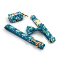 Load image into Gallery viewer, Blue tie-dye dog collar with gold buckle, matching leash, bow tie, and waste bag holder close-up