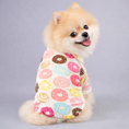 Charger l'image dans la visionneuse de la galerie, Small fluffy dog wearing white pajamas covered in various colorful donuts pattern, sitting and looking back happily