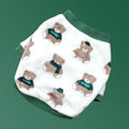 Cargar la imagen en la vista de la galería, Flat lay of white fleece dog sweater with teddy bear pattern and green ribbed collar and cuffs on green background