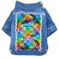 Charger l'image dans la visionneuse de la galerie, Flat lay of blue denim dog jacket displaying colorful sequin patch on the back with frayed detailing
