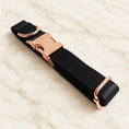 Load image into Gallery viewer, Folded black collar showing the rose-gold-tone buckle, D-ring and adjustment slider