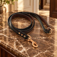 Cargar la imagen en la vista de la galería, Black dog leash with coloured stitching and rose-gold clasp on brown marble