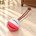 Charger l'image dans la visionneuse de la galerie, White and pink dog chew ball with short brown pullcord on light ivory-beige marble
