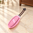 Charger l'image dans la visionneuse de la galerie, Pink oval dog chew toy with short dark pullcord on light ivory-beige marble