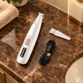 Load image into Gallery viewer, White pet trimmer with cleaning brush and USB cable on brown marble