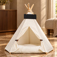 Cargar la imagen en la vista de la galería, White canvas pet teepee with wooden poles and matching cushion in a warm marble and walnut interior.