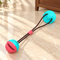 Charger l'image dans la visionneuse de la galerie, Turquoise and coral suction-cup tug ball dog toy with connecting rope on light ivory-beige marble.