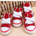 Charger l'image dans la visionneuse de la galerie, Group of red mini canvas dog sneakers with white laces arranged on neutral surface