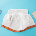 Load image into Gallery viewer, Close-up of inside fleece lining of orange-brown dog jacket laid flat on blue background