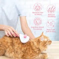 Load image into Gallery viewer, Person grooming an orange tabby cat using pink pet hair remover brush