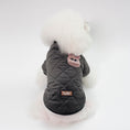 Load image into Gallery viewer, White fluffy dog seen from back wearing charcoal gray quilted jacket with embroidered animal patch