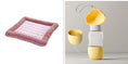 Load image into Gallery viewer, Pink cooling pet bed mat next to yellow pet food and water feeder with heart decorations and food container.