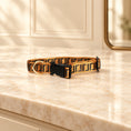 Load image into Gallery viewer, Tan and black Greek key dog collar with black buckle and gold-tone D-ring on beige marble