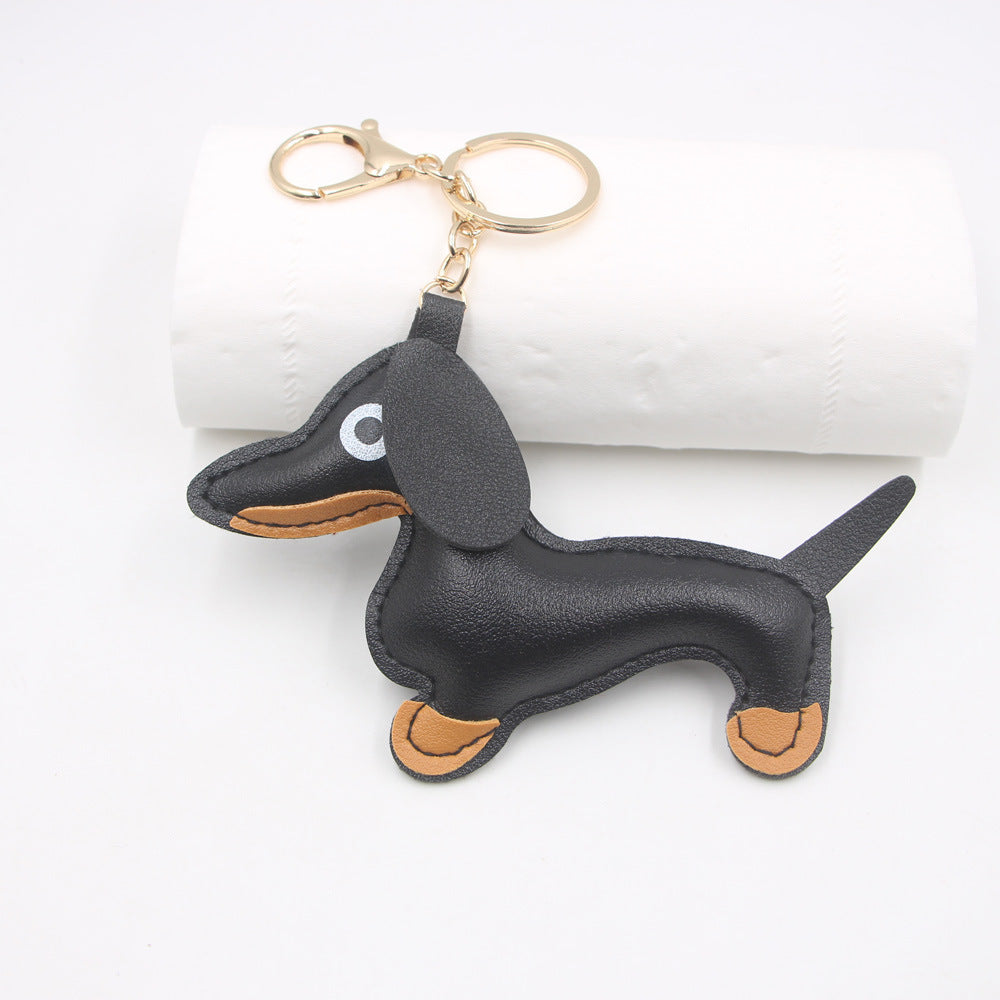 Black faux leather sausage dog keychain displayed on a white background
