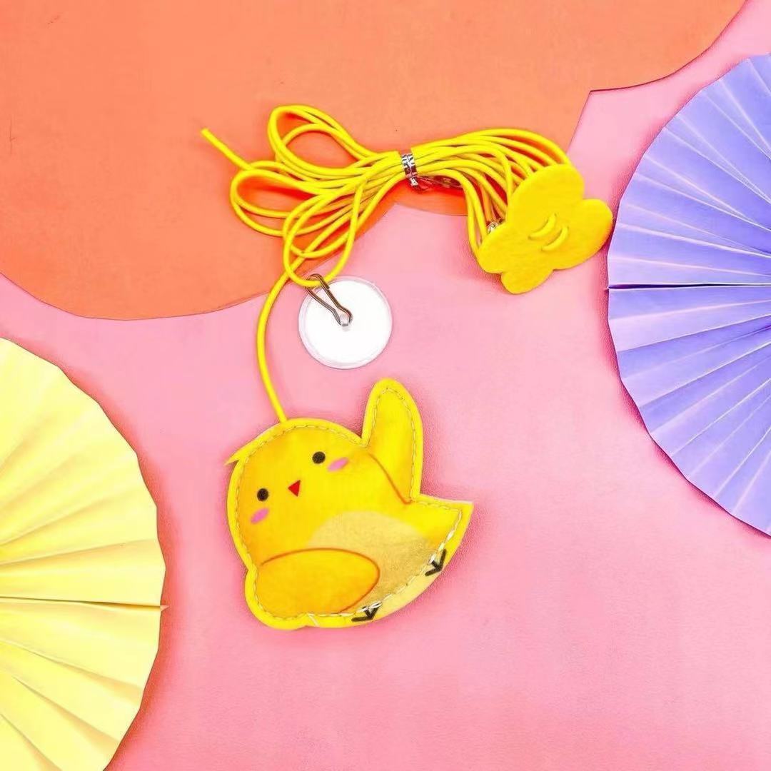 Felt chick-shaped cat toy with yellow elastic rope on pink background