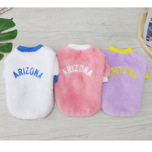 Three Arizona fleece dog jumpers in white, pink, and lavender colors laid flat on wood background