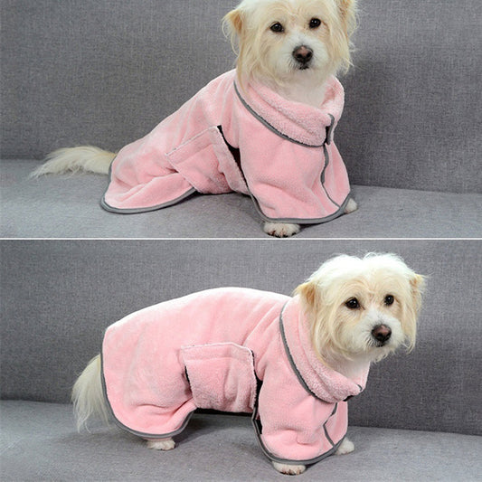 Small white dog wearing a pink microfiber drying robe sitting on gray couch, front view