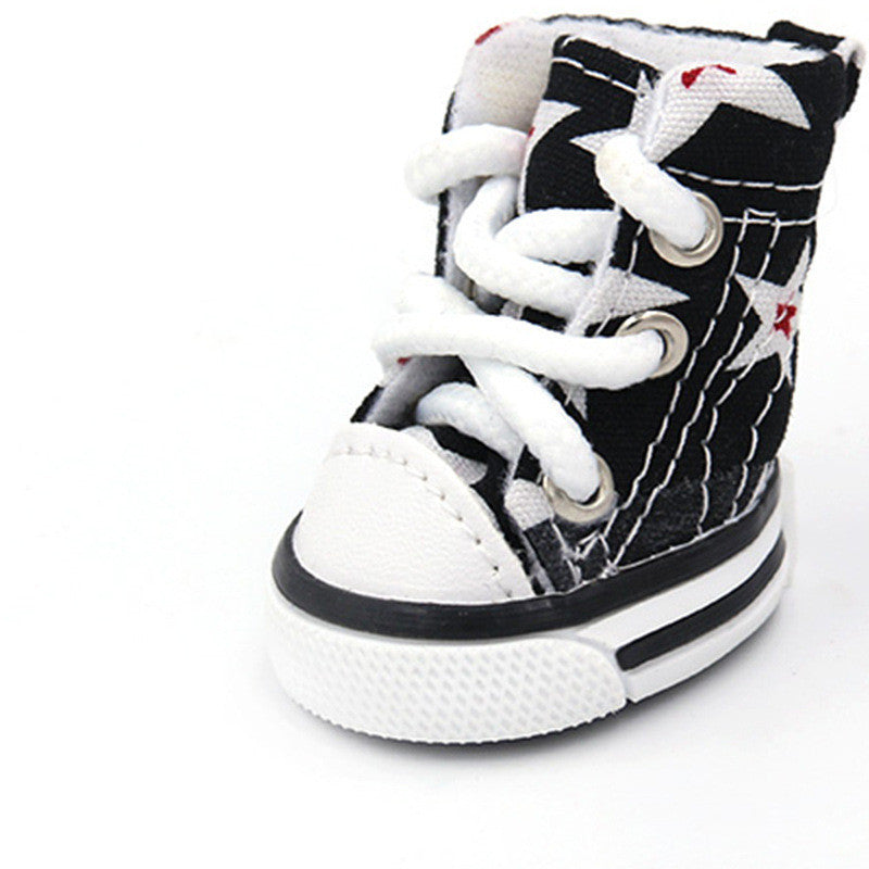 Close-up angled view of black and white star print dog shoe with white padded interior