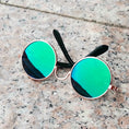 Load image into Gallery viewer, Metallic gold-framed round sunglasses with rainbow mirrored lenses on stone surface
