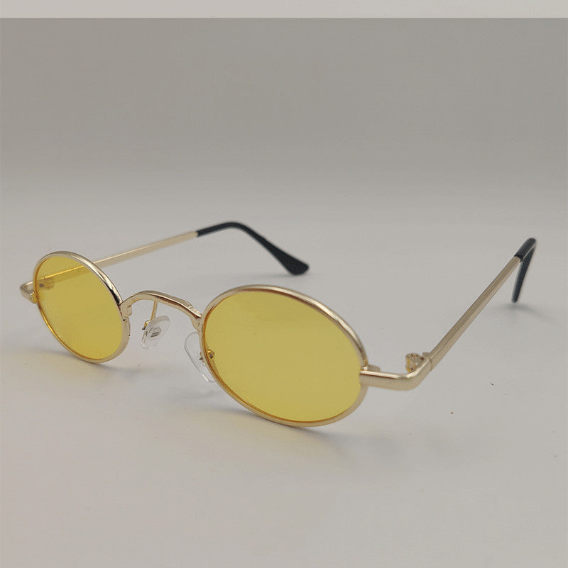 Yellow oval dog sunglasses toy on white background with black ear tips