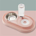 Cargar la imagen en la vista de la galería, Pink automatic pet feeding station with stainless steel bowl and water bottle on pink surface

