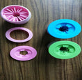 Load image into Gallery viewer, Disassembled silicone dog paw washer parts in pink, blue, and green on wooden surface
