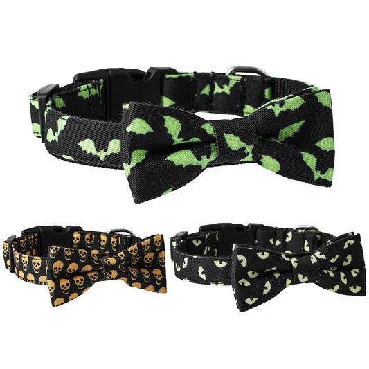 Three pet collars with bow ties featuring Halloween designs: green bats, yellow skulls, and glowing eyes on black nylon straps