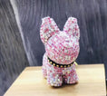Charger l'image dans la visionneuse de la galerie, Close-up of pink crystal dog keychain sitting on a wooden block against a dark rustic background
