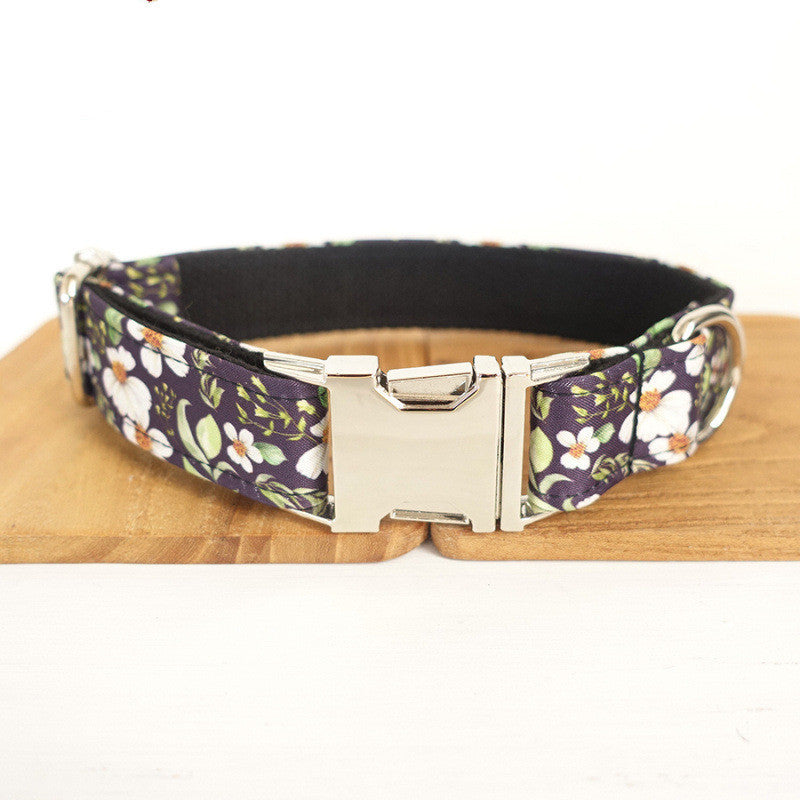 Adjustable purple floral dog collar with silver quick-release buckle displayed on wooden board