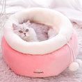 Load image into Gallery viewer, White fluffy cat lying inside pink round plush cat bed with white fleece collar and pom-poms
