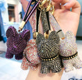 Charger l'image dans la visionneuse de la galerie, Hand holding several crystal dog keychains in multiple colors showing close-up of textured crystal stones
