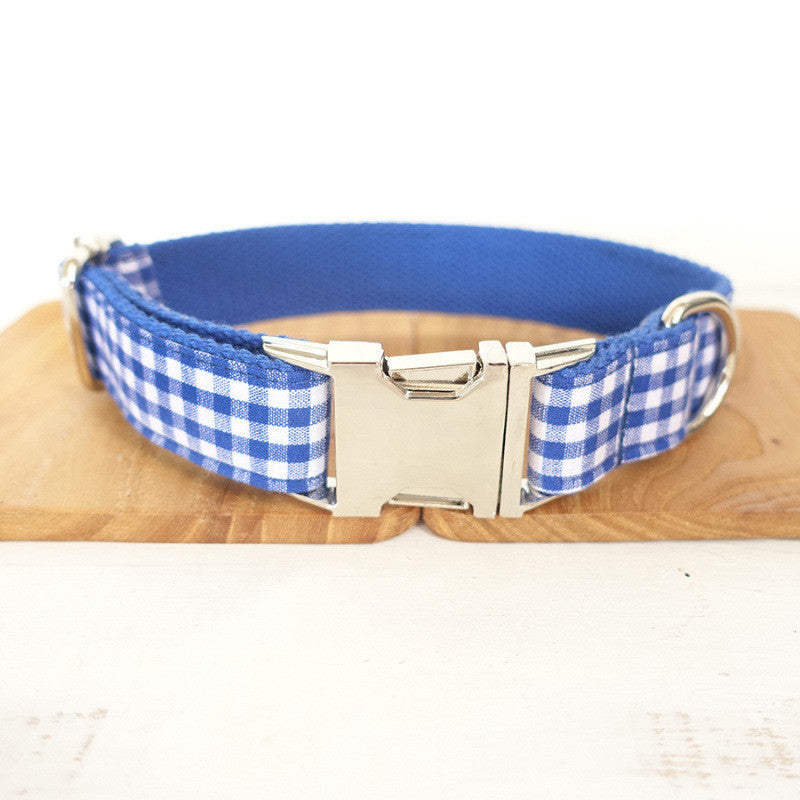 Close-up of metal buckle and D-ring on blue plaid adjustable collar