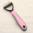 Load image into Gallery viewer, Two dog grooming combs with pink and blue handles side by side on wooden surface
